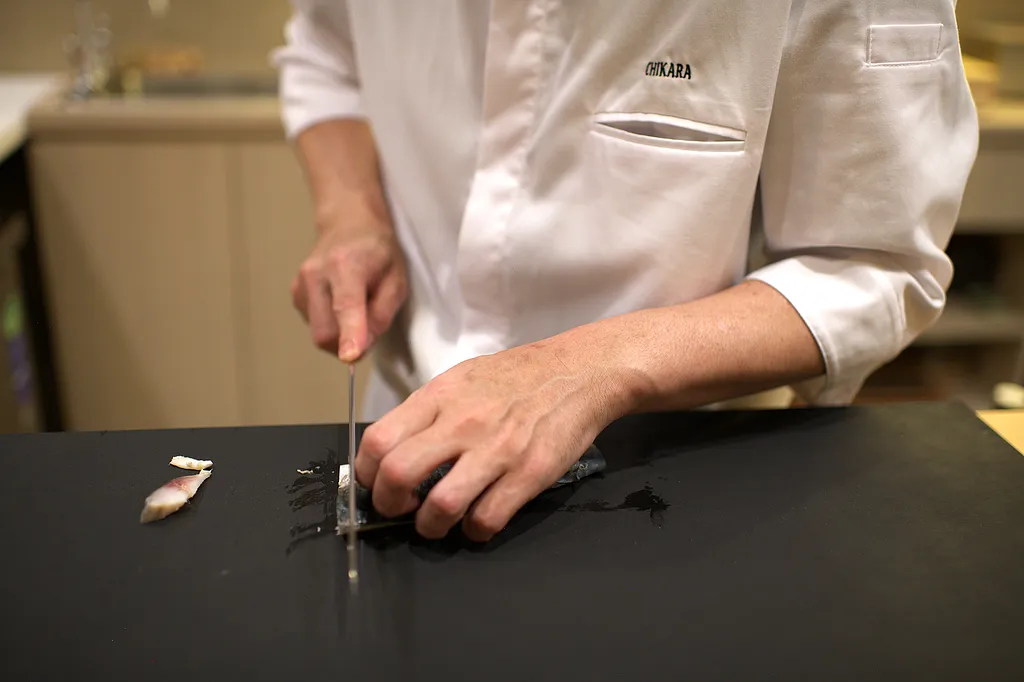 The chef cutting on a dark board
