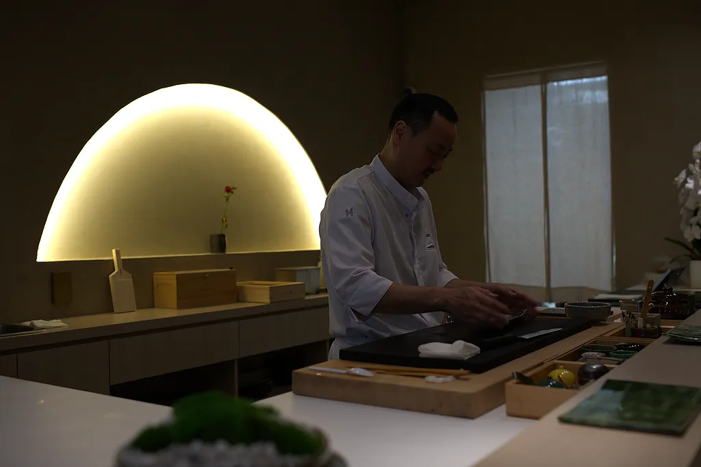 The chef working beneath the arched light