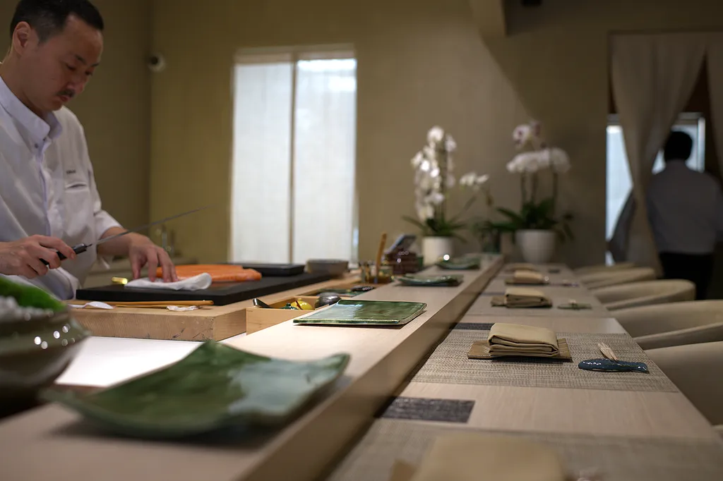 The chef slicing fish along the counter